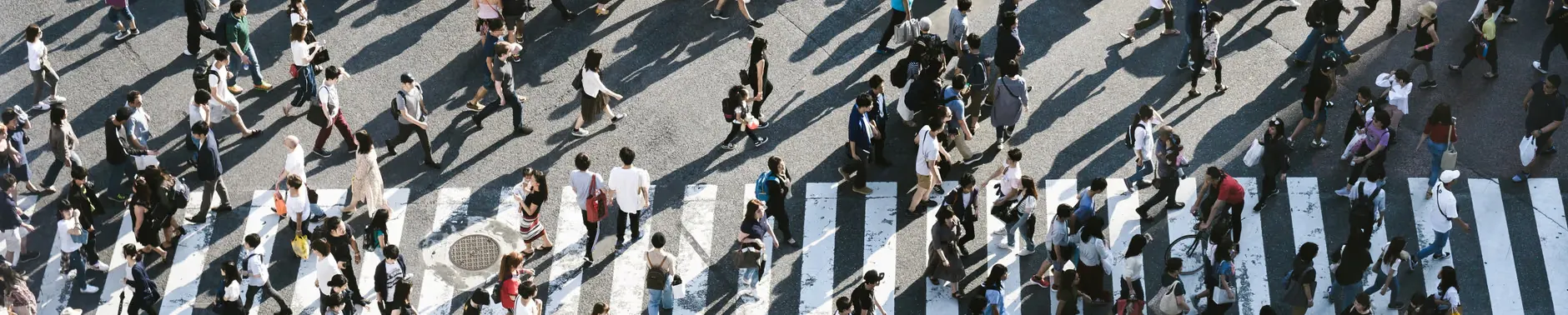 A crowd of people crossing a city intersection
