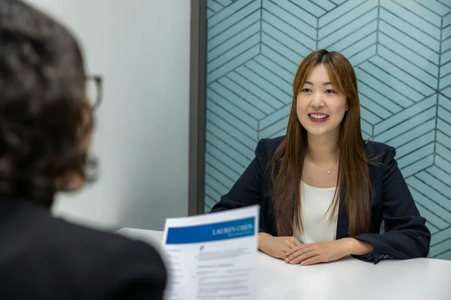 A candidate being interviewed across a desk